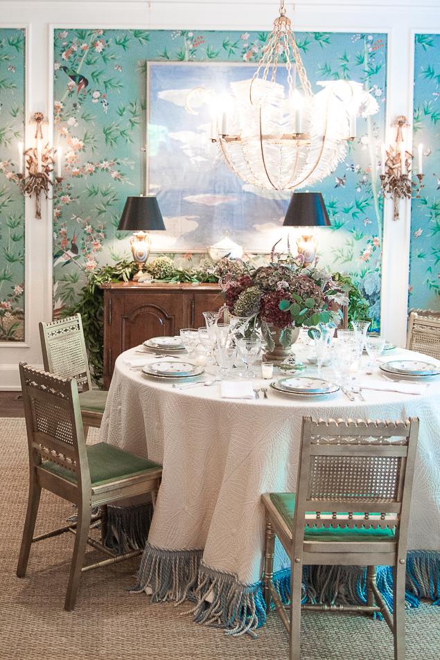 Chinoiserie dining room featuring feather crystal chandelier, gold accents, round table and vintage gold chairs, Chinoiserie aqua wallpaper www.pencilshavingsstudio.com