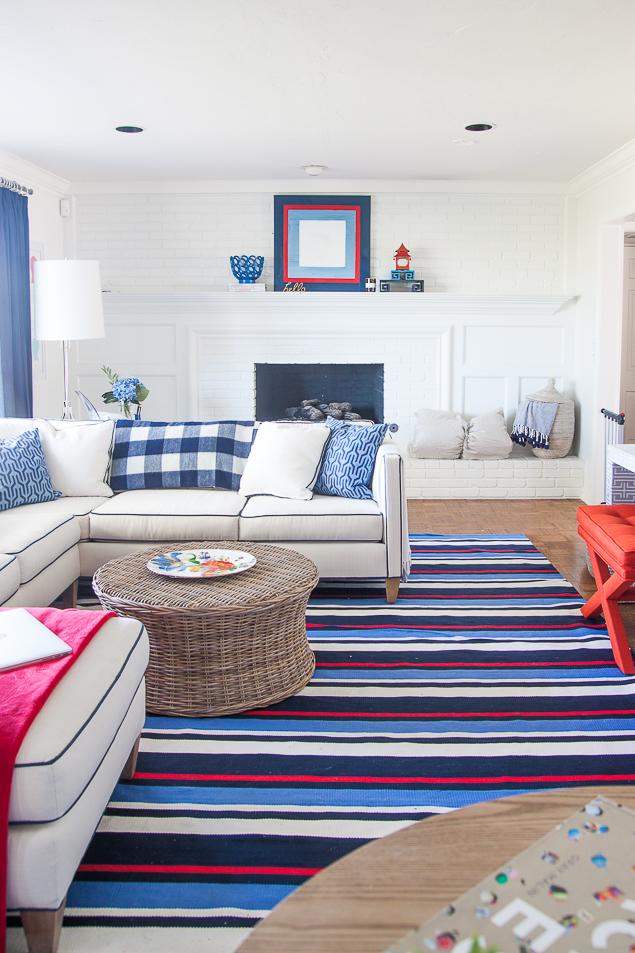 Pencil Shavings's One Room Challenge living room reveal, complete with loads of bold blues and accented with red. Check out the full reveal inspired by the preppy regatta stripe rug from Dash & Albert, plus a kidfriendly white sofa. www.pencilshavingsstudio.com