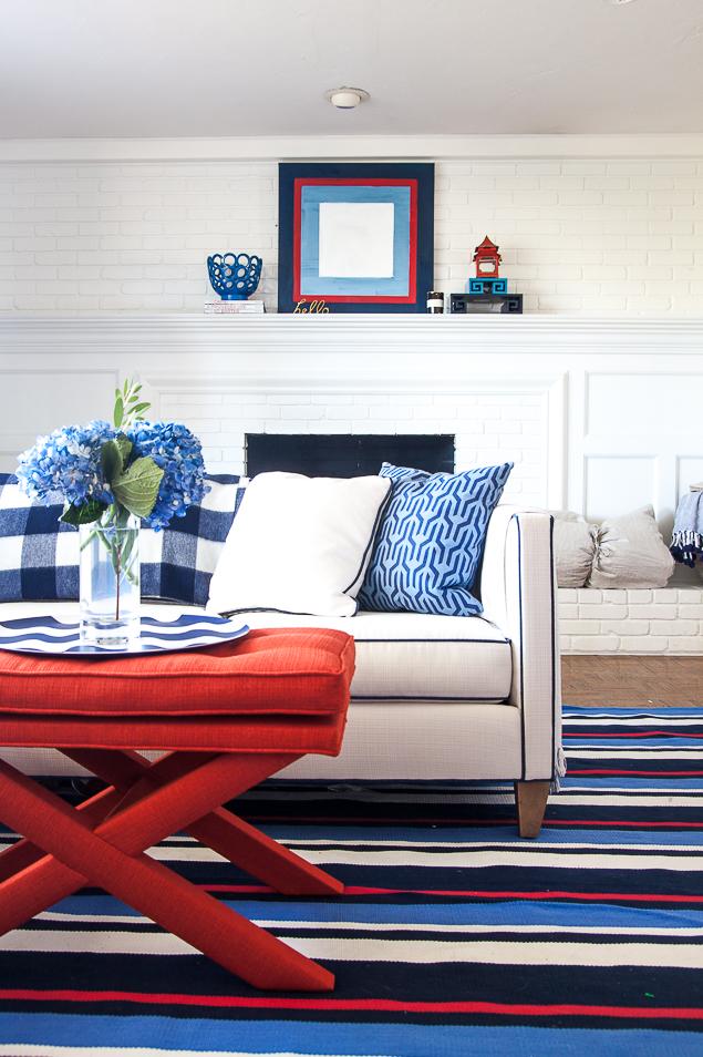 Pencil Shavings's One Room Challenge living room reveal, complete with loads of bold blues and accented with red. Check out the full reveal inspired by the preppy regatta stripe rug from Dash & Albert, plus a kidfriendly white sofa. www.pencilshavingsstudio.com